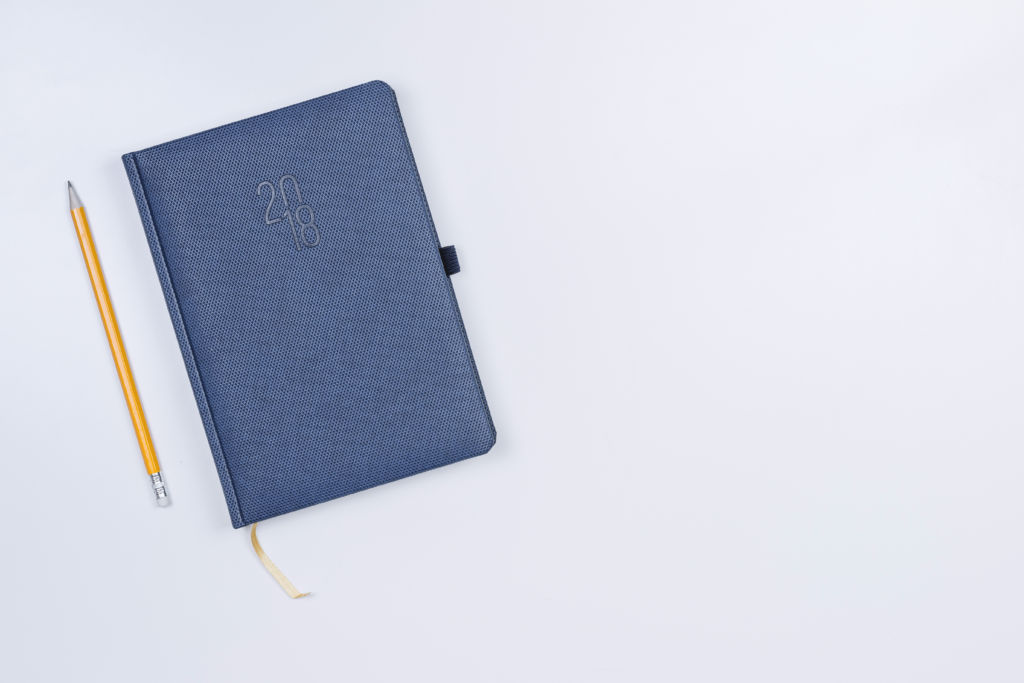 Pretty diary with a pencil on the white table. · Free Stock Photos