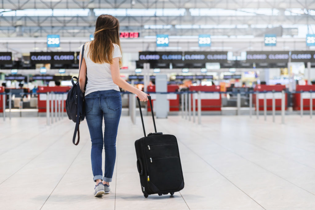 Rear view of young woman with luggage in airport · Free StockPhotos